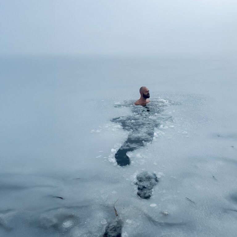 Olivier Passebecq swimming through ice in misty water